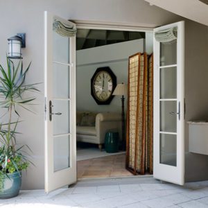 A set of French Doors in white with four window panes and blinds.